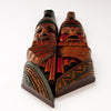pair wood tribal carving faces playing panpipes