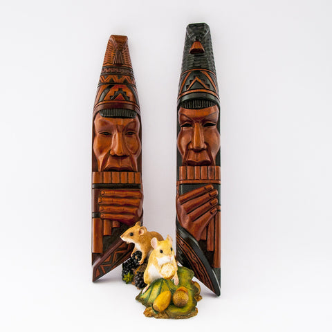 pair wood tribal carving faces playing panpipes